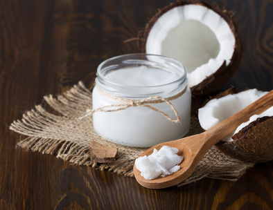 Coconut oil and fresh coconut on wooden table